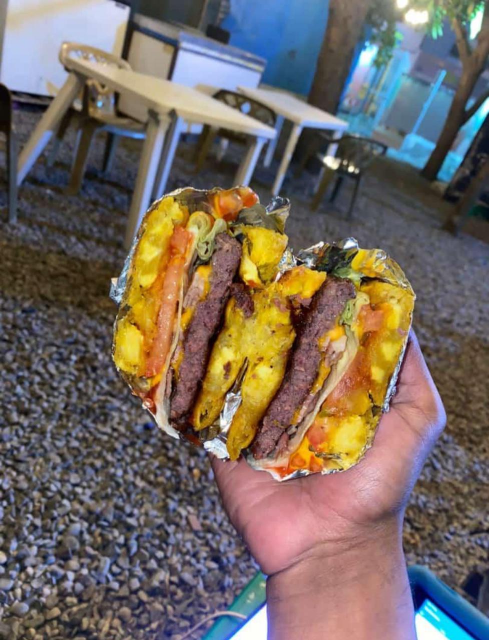 Burrito envuelto en papel aluminio sostenido en mano